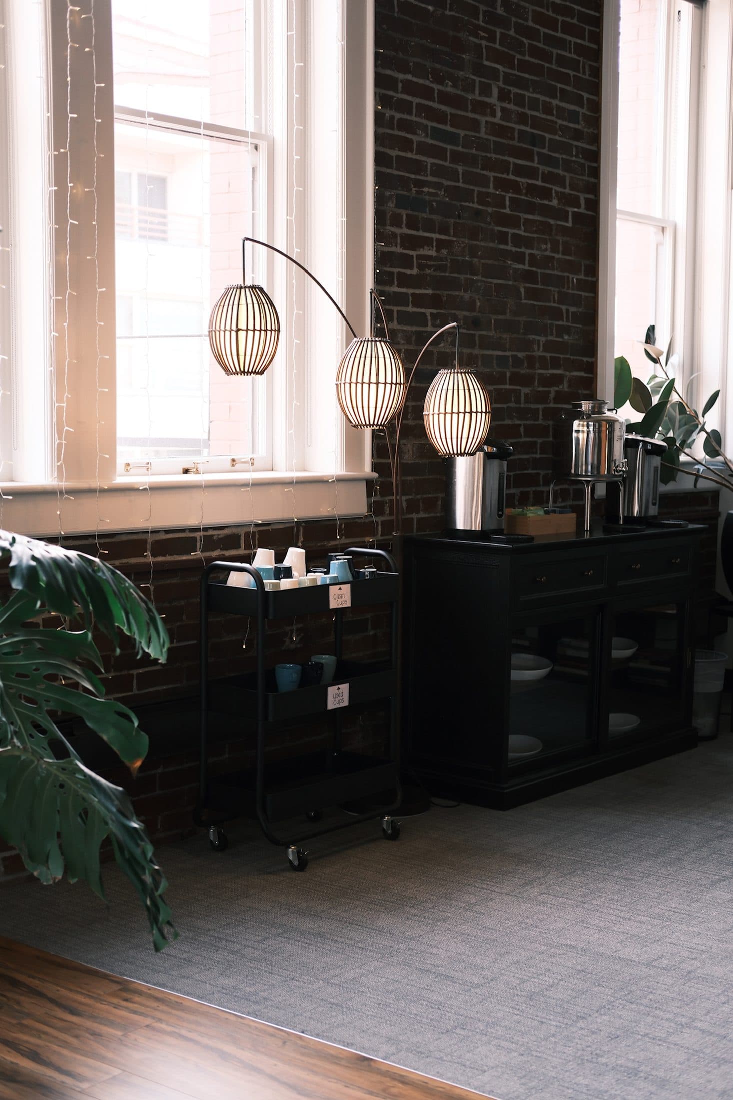 Tea service carts and woven lanterns along a brick wall