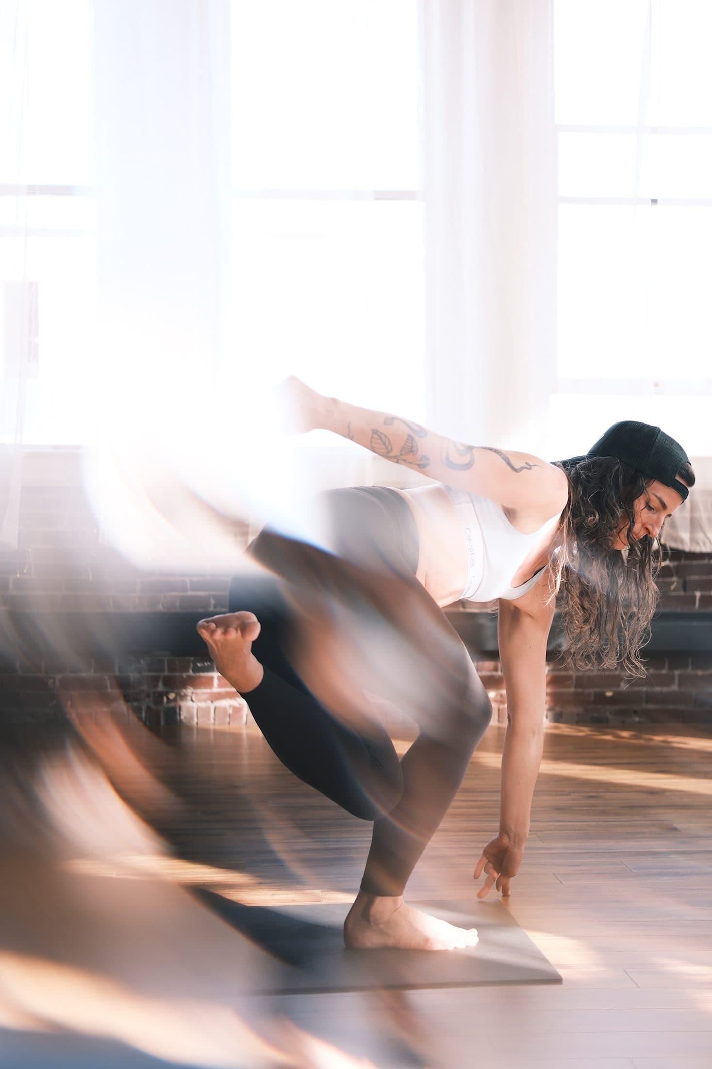 Long-exposure photograph of a standing balance blurring into motion in warm light
